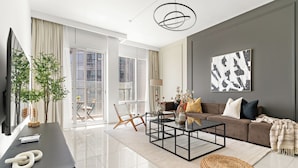 A modern living room with a sofa, coffee table, and a large window.