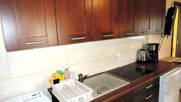 Frigorífico, placa de cocina, cafetera o tetera y mesa de comedor