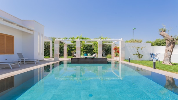 A modern swimming pool with a pergola and lounge chairs. - Affittacamere Incanto nel Verde by Wonderful Italy (Polignano a Mare)