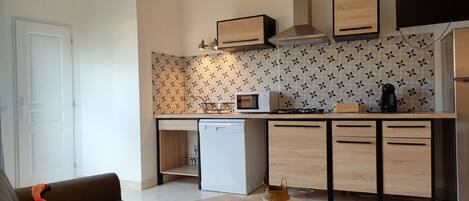 A compact kitchen with a microwave, stove, and dishwasher.