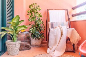 Een gezellige kamer met een houten schilderstandaard, een witte handdoek en twee planten in potten.