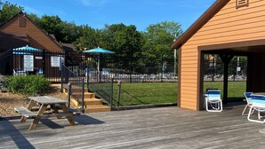 A wooden deck with picnic tables and a covered seating area. - Pool open beyond Labor Day! Enjoy the quiet! (Champion)