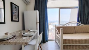 Une chambre comprenant un coin repas, un lit et une vue sur la mer.