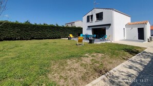 Un bâtiment moderne à deux étages, doté d’un toit plat, d’un grand patio ouvert avec des espaces de détente en plein air et d’une pelouse bien entretenue.