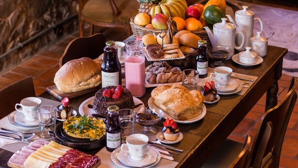 A breakfast buffet with various food items, beverages, and a fruit basket.