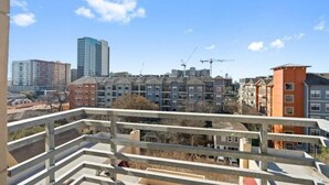 En vy över ett bostadsområde med flerfamiljshus, inklusive en blandning av hyresfastigheter och villor, under en klar himmel.