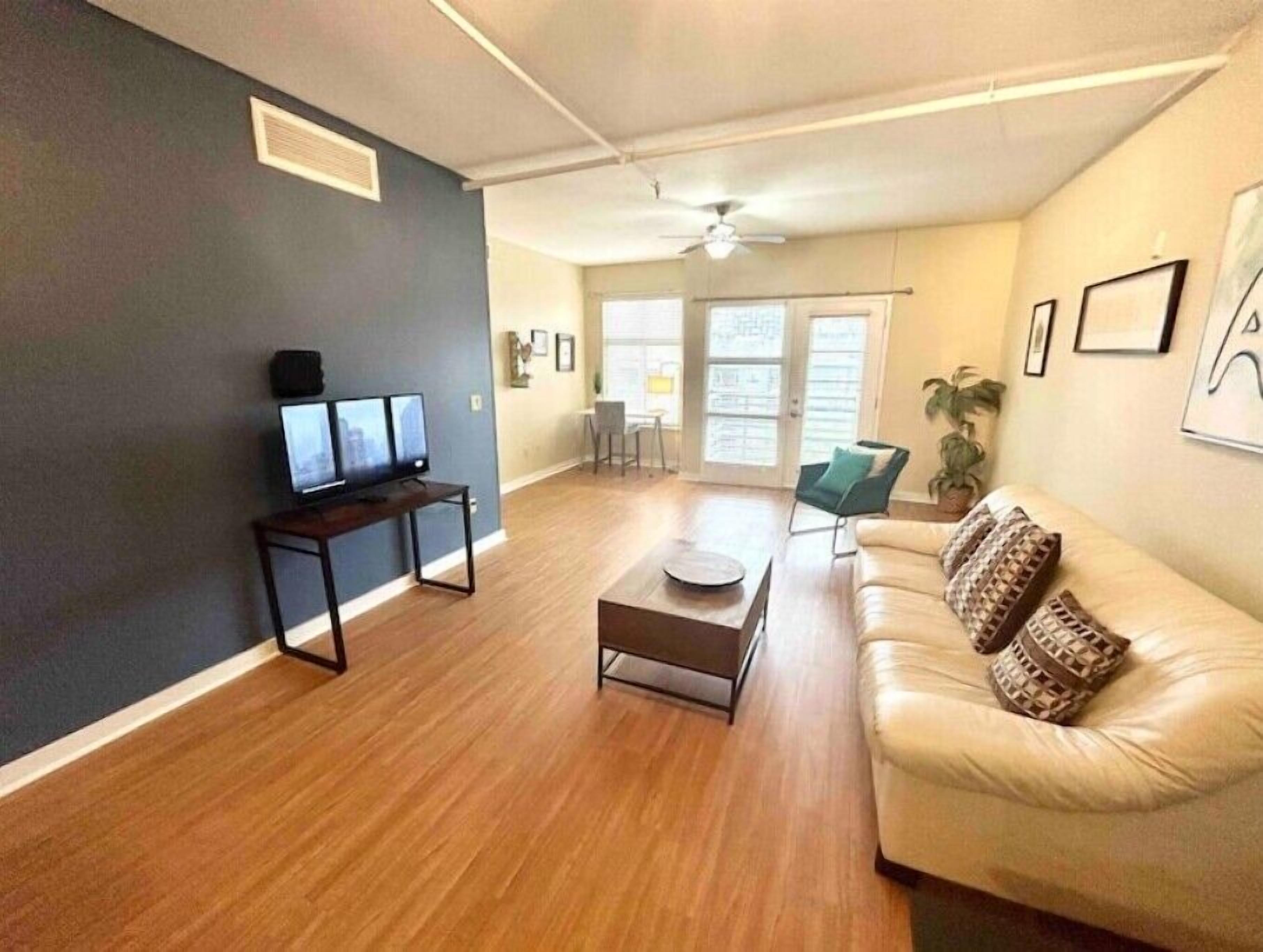 Un salon avec un canapé, une table basse et un téléviseur posé sur un meuble.