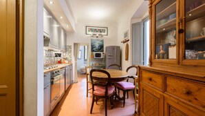 A kitchen with a dining table, chairs, cabinets, and a microwave. - Casa torre via de' Neri by Mmega (Florence)