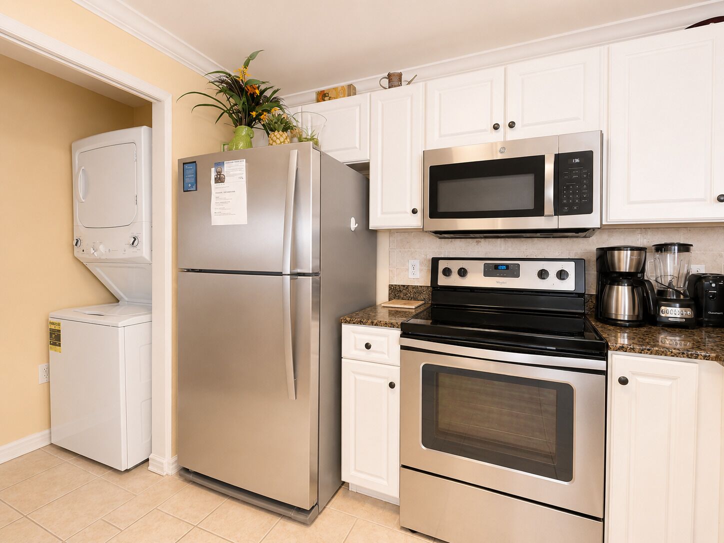 A kitchen with a stainless steel refrigerator, microwave, stove, and oven.