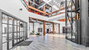 Een ruime atrium met een hoge plafond, meerdere niveaus en een centraal open gedeelte met zitplaatsen.