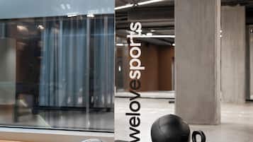 A gym area with exercise equipment, a concrete pillar, and a glass wall.