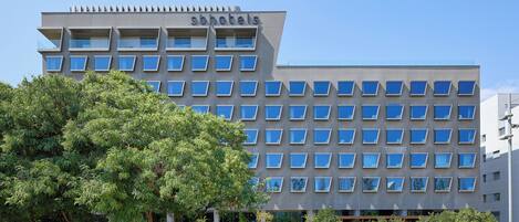 Un edificio moderno de hotel con una fachada de ventanas enrejada, techo plano y un letrero que dice 'sonotels'.