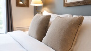 A neatly made bed with white linens and two beige pillows. - Bearmont- Pool, HotTub, FirePit, AC, Gym, Sauna (Killington)