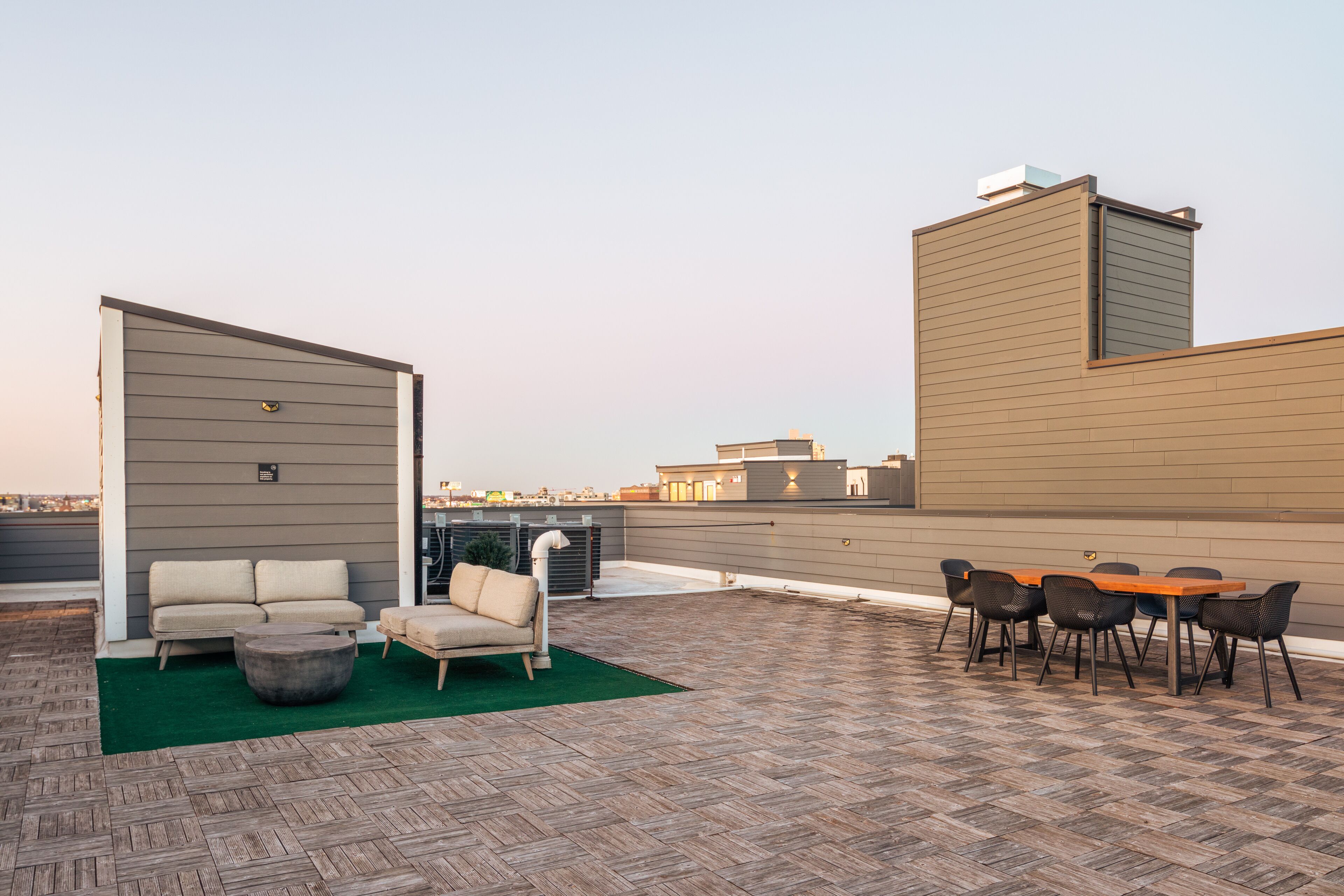 Une terrasse sur le toit avec un canapé, des chaises et une table.