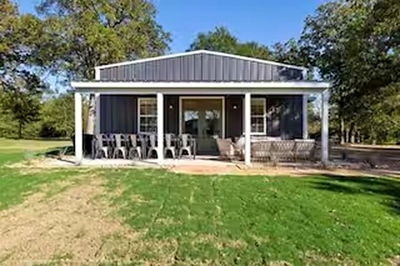 A single-story building with a porch and outdoor seating area.