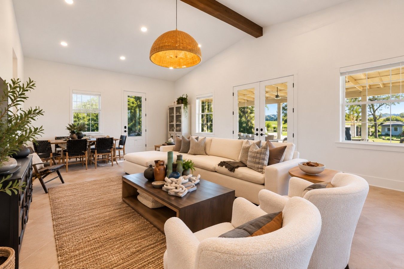A spacious living room with a sofa set, a coffee table, and a dining area with chairs and a table.