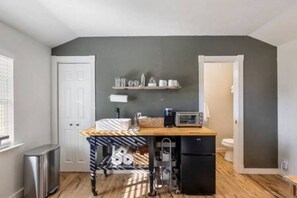A compact kitchen with a refrigerator, microwave, and a small sink. There is a window on the left and a door leading to another room. - Cottage at Fable Farm, mins from Round Top/Brenham (Brenham)
