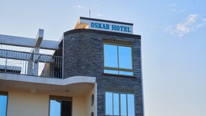 Ein Hotel mit modernem Design, mit einem gut sichtbaren Schild, das im oberen Bereich "OSKAB HOTEL" zeigt.