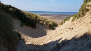 A beach with sand dunes and sparse vegetation. - Nollaig  Beachside Bliss - Pass the Keys (Rye)