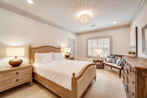 A bedroom with a large bed, bedside tables, a bench, and a dresser. - Modern Serenity: 3 Beds of Calm & Style (Dallas)