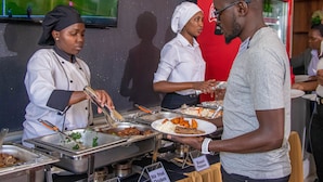 A buffet with various food options, including stir-fried chicken and roast potatoes. - WAFFLES SUITES (Nakuru)