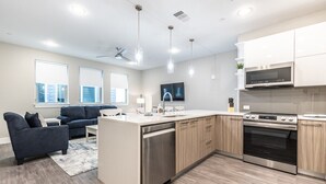 Una cocina moderna con una isla central, electrodomésticos de acero inoxidable y un horno empotrado.
