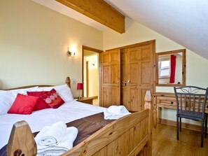 A bedroom with a bed, a wooden desk, a chair, and a wardrobe. - Beech Lodge - Retallack Resort (St Columb)