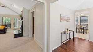 A spacious living area with a high ceiling, a dining area with a table and chairs, and a view of the outdoors through large windows. - Cozy Nest-3-Bedroom Charm In Plano (Plano)