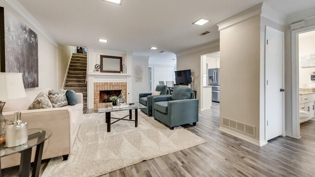 A spacious living room with a fireplace, a sofa set, and a dining area.