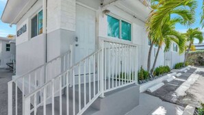 A white building with a balcony and a staircase leading to the entrance. - Sun-kissed Charm: Beachside Hollywood Studio (Hollywood)