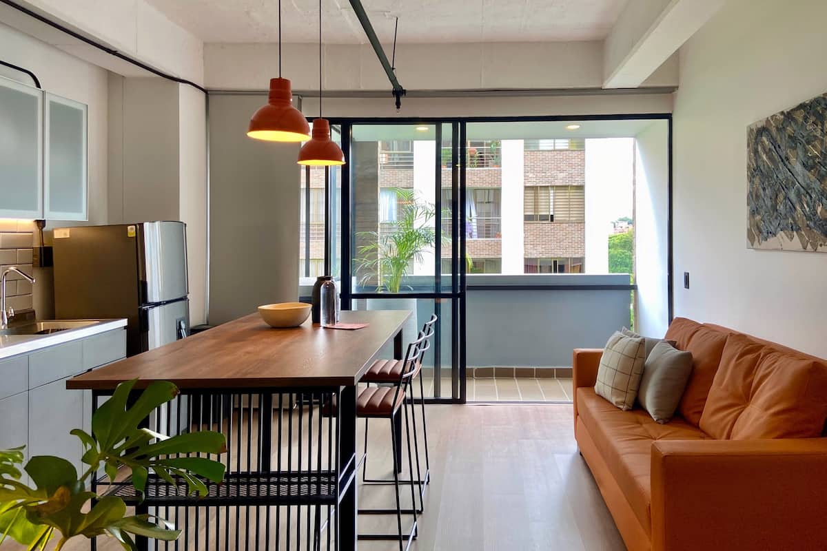 Een moderne keuken met een houten tafel, een koelkast en hanglampen.