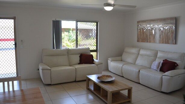 A living room with two sofas, a coffee table, and a ceiling fan. - Alice Street 1, Unit 1, Currimundi (Currimundi)