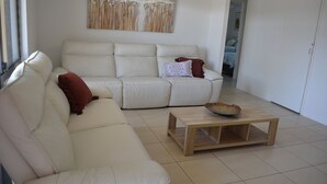 A living room with a beige sofa, a wooden coffee table, and a decorative bowl. - Alice Street 1, Unit 1, Currimundi (Currimundi)