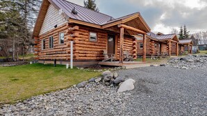 A log cabin with a porch and a metal roof. - Lakeshore Cabins (Homer)