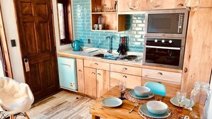 Una cocina compacta con encimera de madera, horno doble y lavabo.