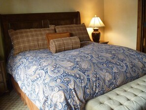 Cozy retreat with a large bed, brown pillows, and a matching headboard.