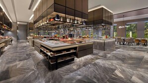 A modern kitchen with a central island, built-in appliances, and a dining area with chairs. - Courtyard by Marriott Gorakhpur (Gorakhpur)