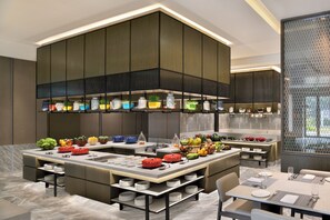 A modern kitchen with a central island, built-in appliances, and a dining area with a table and chairs.