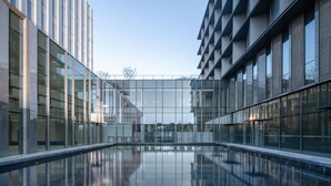 Ein modernes Gebäude mit Glasfassade und einem Innenhof.