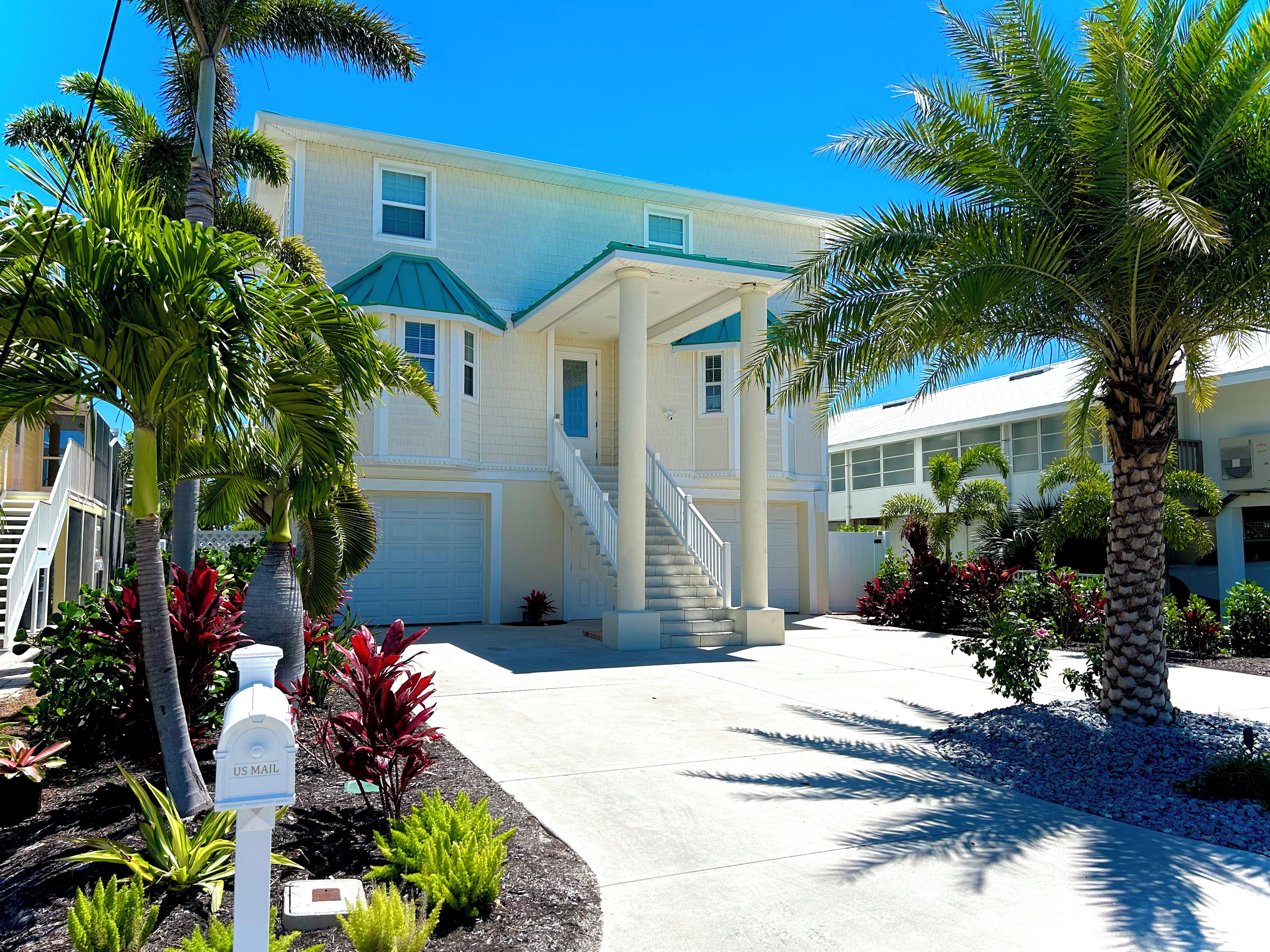 A two-story house with a front porch, a staircase, and a driveway.