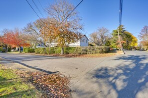 Una strada residenziale con case, alberi e cielo sereno.