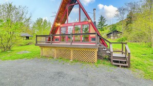 A triangular wooden cabin with a balcony and stairs leading up to it, surrounded by greenery. - Walk to Ski Lift! Charming Hunter A-Frame (Lanesville)