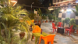 An outdoor seating area with tables and chairs, surrounded by potted plants. - ANAND LOK VARANASI  (Varanasi)