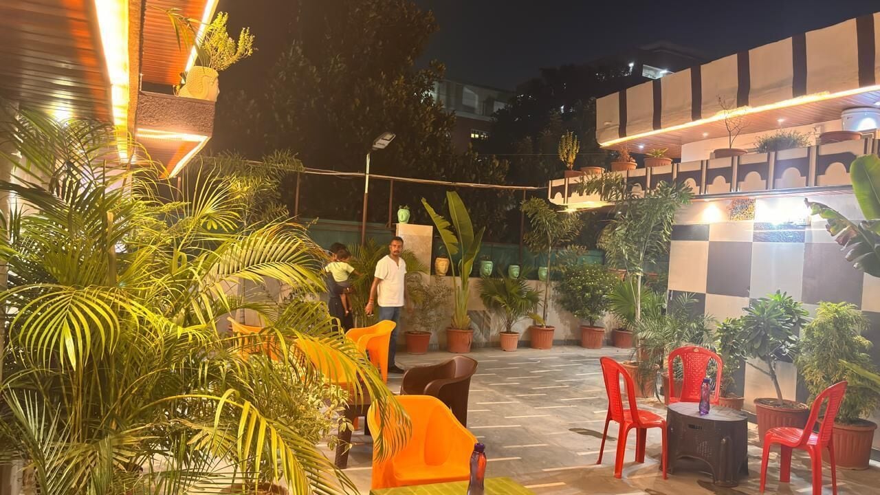 An outdoor seating area with chairs and tables, surrounded by potted plants.