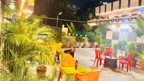 An outdoor seating area with potted plants and chairs. - ANAND LOK VARANASI  (Varanasi)