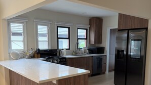 A modern kitchen with a central island, stainless steel appliances, and large windows. - Fully Renovated 2 BR House by Palos Verdes, Beach, in Quiet Neighborhood (Los Angeles)