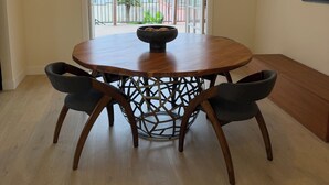 A dining area with a round table, two chairs, a ceiling fan, and a view through an open door to a balcony. - Fully Renovated 2 BR House by Palos Verdes, Beach, in Quiet Neighborhood (Los Angeles)