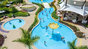 A resort with multiple swimming pools, water slides, and outdoor seating areas.