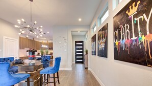 Una cocina moderna con armarios de madera, una isla central con taburetes de bar y una lámpara de techo.