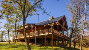 A large wooden cabin with a balcony, surrounded by trees. - Highland Lodge With Indoor Saltwater Pool (Rockbridge)
